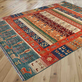 A rectangular area rug with a colourful tribal-style geometric pattern, with some quirky animals laid out on a light-colored wooden floor.