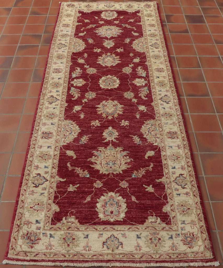 Wine red central ground on this runner with shades of cream used in the border and in the decorative work in the central area.  Blue and green are used to highlight certain areas of the design work.