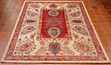 A beautiful Afghan Aryana rug hand knotted using a design from Central Asia. Very often this design can be found in exquisite silk embroideries made by hand in Uzbekistan. There is a panel in the centre of the rug in a soft almost pinkish red with a narrow border in gold . The background to the wide main border is a cream colour and other shades used are Wedgwood blue, dark green , peach and deep blue. The construction is wool on to a cotton foundation.