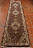 Intricate network of flowers across the entire rug with three main decorative motifs on a cream background, the border uses the same cream.  The tremainder of the decoration is on a black background with the decoration using earthy tones of red, green and gold. 