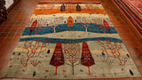 Stylised tree design Afghan rug in colourings of pale grey, mid blue, old gold, cream and brick red