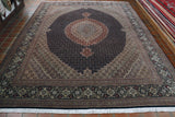 Hand-knotted in northwest Iran, this finely woven Tabriz carpet is a stunning example of the most delicate Persian weaving. The primary colourings used are a very dark navy with rust, cream, gold, soft green and tiny touches of red. The intricate wool pile is very densely woven onto a cotton foundation.