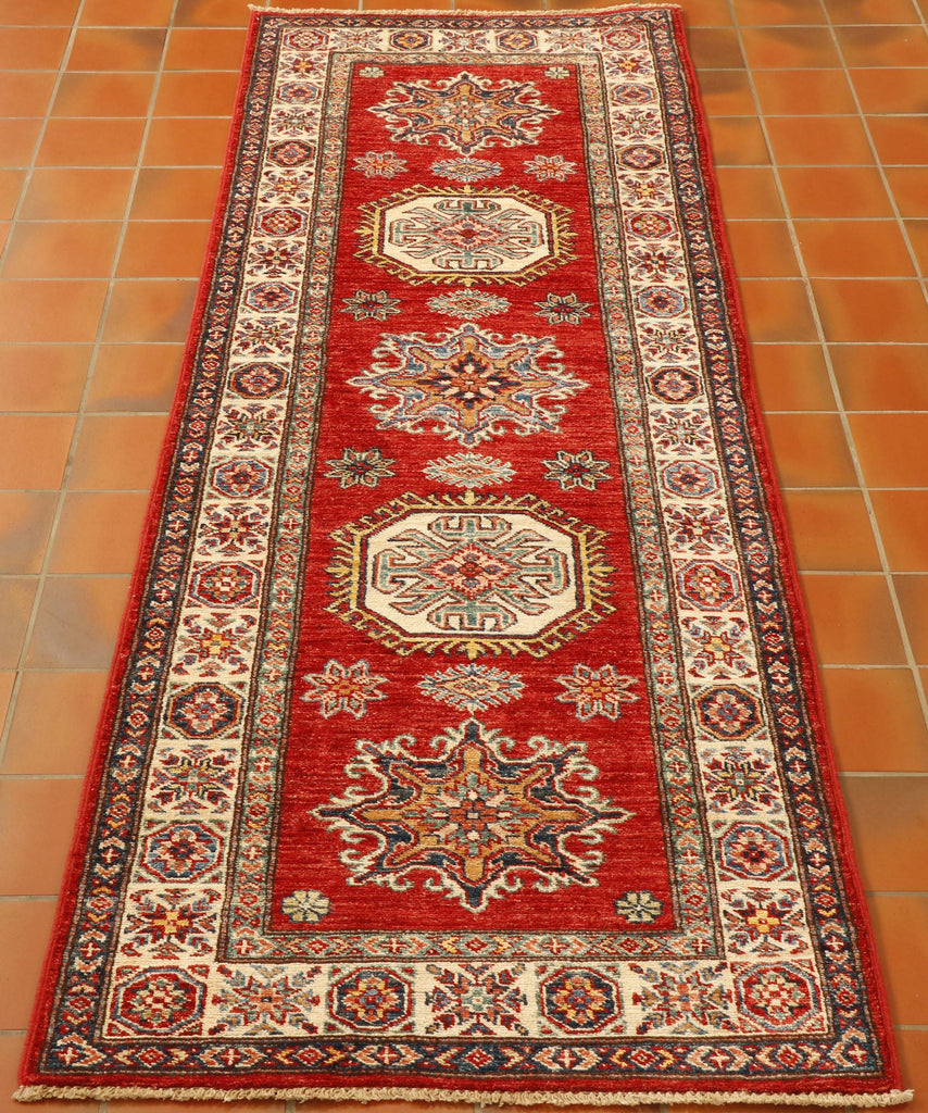 A rich tomato background with an ivory border and gold, light blue and dark blue have been used in this fine Afghan Kazak runner.