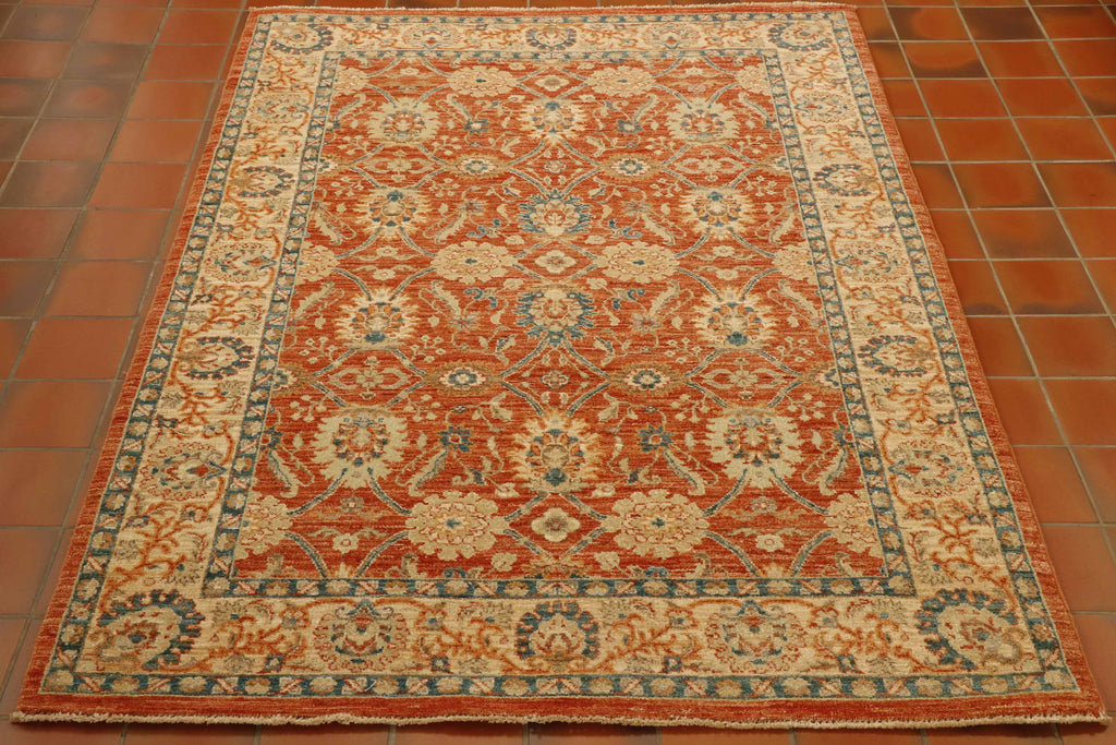 Soft terracotta ground with a blue and cream decoration of flora. Cream border with similar floral design but using the terracotta and blue as the colour palette. Soft green used for highlights.
