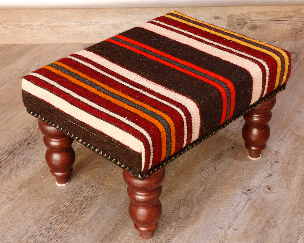 Theses Turkish Kilim stools often uses salvaged pieces.  This use produces an interesting look with the pattern being offset rather than centred, making the pieces unique and different.  This stool has bands of colour going across it’s width.  The colour palette for this stool is rich in Autumnal tones, oranges, browns, red, and ivory.  