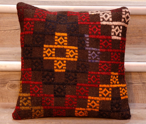 The pieces are often salvaged from old kilim so the pattern or Motifs may be cut in unusual and interesting ways.   This cushion has a geometrical pattern upon a dark brown ground.  The decoration is a series of decorated squares in golden yellow, black, purple, red and cream.  