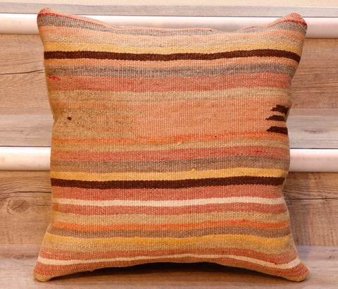 The pieces are often salvaged from old kilim so the pattern may be cut in unusual and interesting ways.  The palette for this cushion is bands of soft peach yellow, brown, cream, orange, fawn.  With the exception of one broad band in the centre of the cushion in peach, the remainder of the bands are the same width. The back of the cushion is usually Faux suede or cotton.