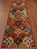 Scallop shapes over the entire body of the rug in various bright colours.  These include golden yellow, sea green, cream, tomato red, dark and light blue, dusky pink and duck egg blue. 