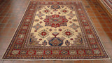 A soft cream central ground with a large central motif in bright red and dark blue. Two smaller motifs at either end in dark blue with additional smaller decoration around using golden yellow, soft green, lime green, peach and pale blue.   There is a complex set of borders, all highly decorated using the same colour palette.  There is one broad border with a red ground and a series of others of varying widths. 