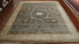 Main central section with a central medallion in a grey/blue.  Area around it is highly and intricately decorated using the same shade plus paler blue, cream and a mustard yellow.  Broad cream border also highly decorated. 