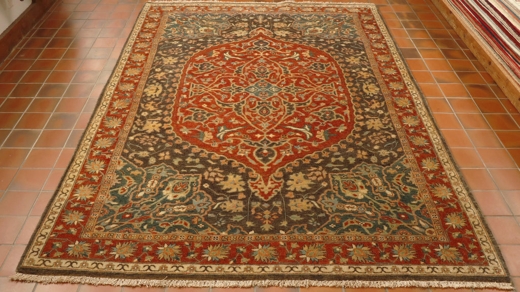 The central medallion is large and covers a significant proportion of the central ground.  It is terracotta with the surrounding area being in a soft browny/blue and soft sea green.  There is a real soft blended look to the colour work and pattern interaction in this piece.   There is a terracotta border with a floral design. 
