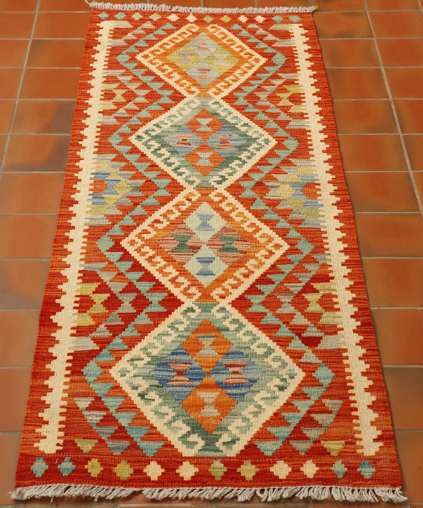 Orange forms the base colour for this runner.  There are 4 lozenges through the length of the runner which use the colours, green, sea blue, dark blue, lime green and ivory. 