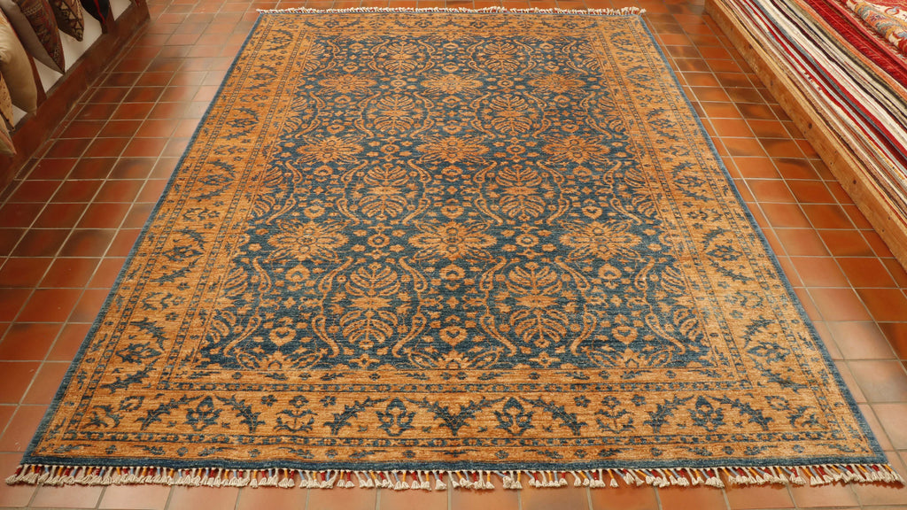 A teal blue rug with a wonderful bold golden decoration in the border and also over the central section.  The decoration is based on fluid and floral decoration. 