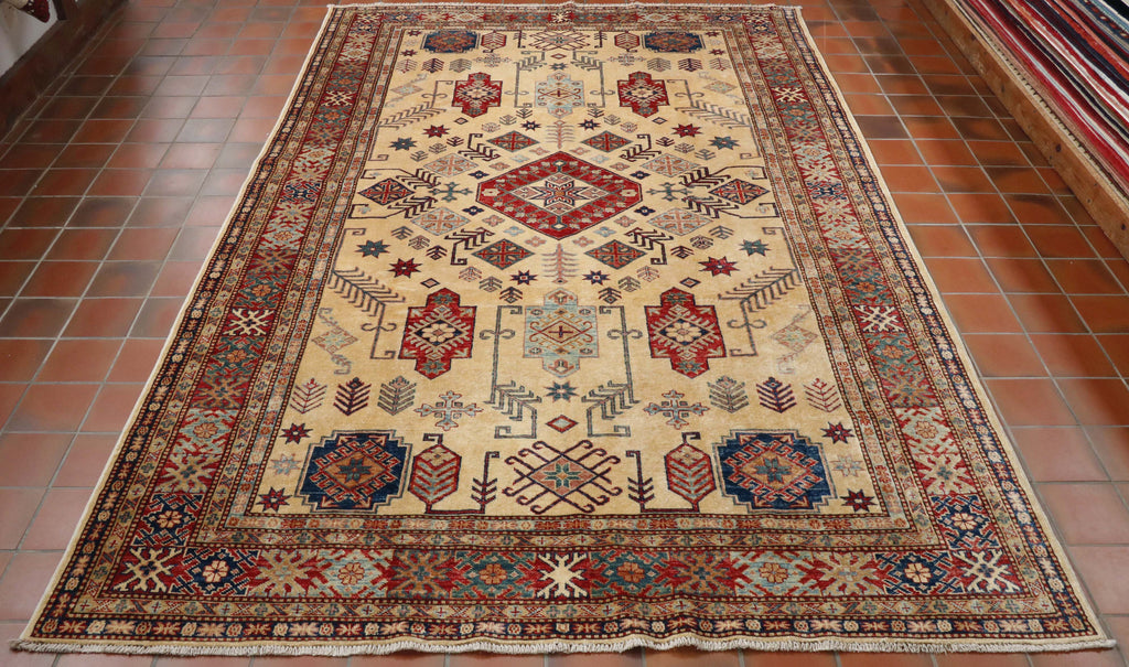 Warm cream central section with borders of varying widths and designs.  All of the decoration is geometric in style.  In the central section there are large motifs using red, light blue, dark blue with highlights in green.  These colours can also be found in the decoration in the borders. 